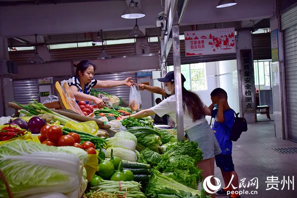 市民正在貴陽紅巖農貿綜合市場購買蔬菜。